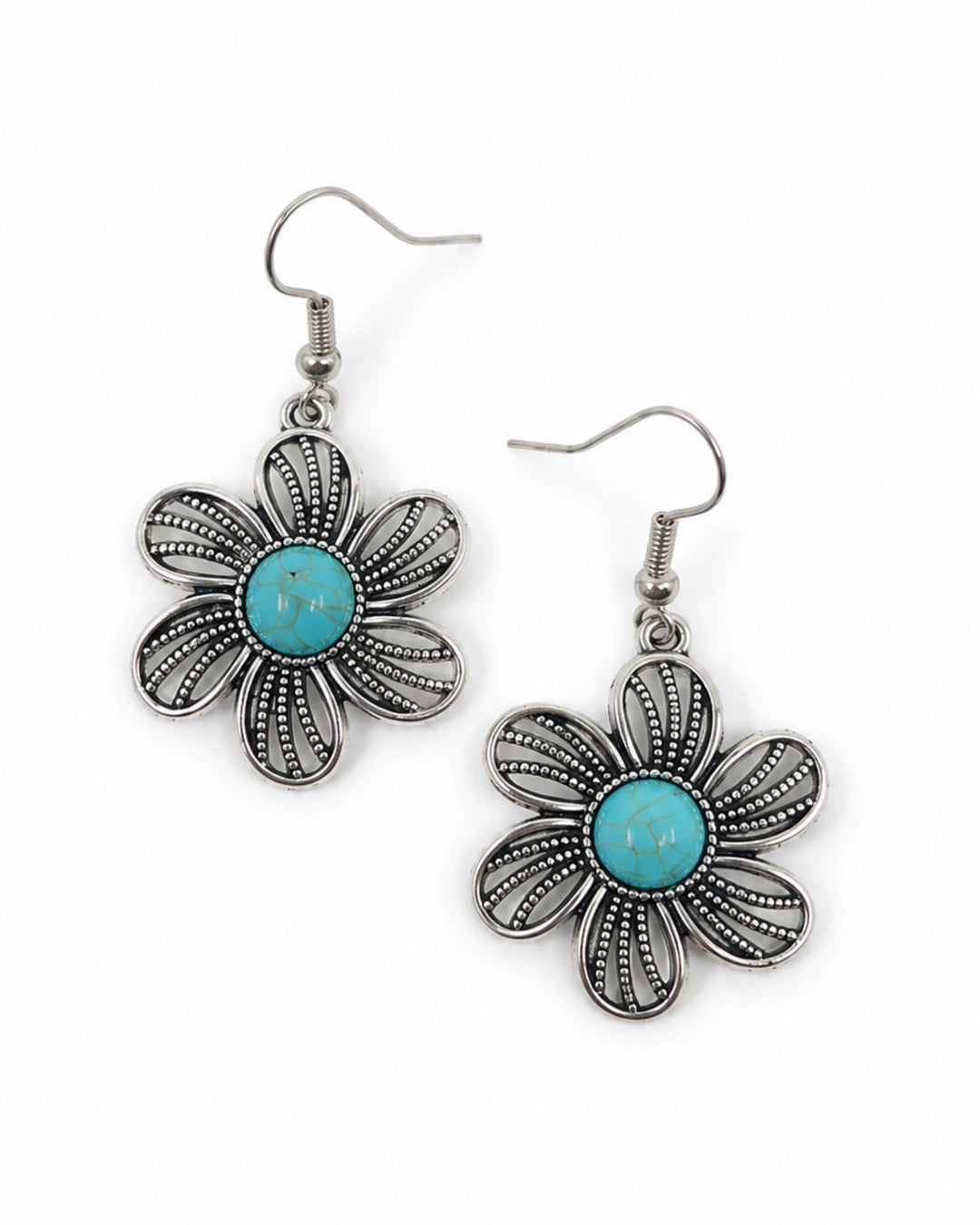 A pair of silver-tone dangle earrings shaped like stylized flowers, featuring a central turquoise blue stone surrounded by textured petal-like filigree details, shown on a plain white background.