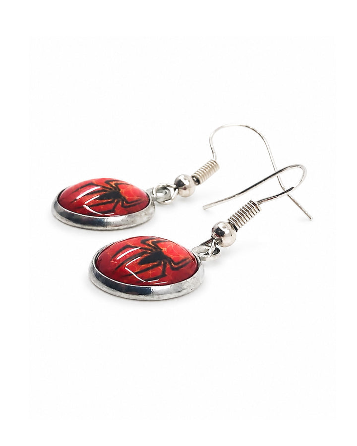 Close-up of Halloween spider drop earrings with red glass cabochon pendants, black spider silhouettes, web detail and silver hooks