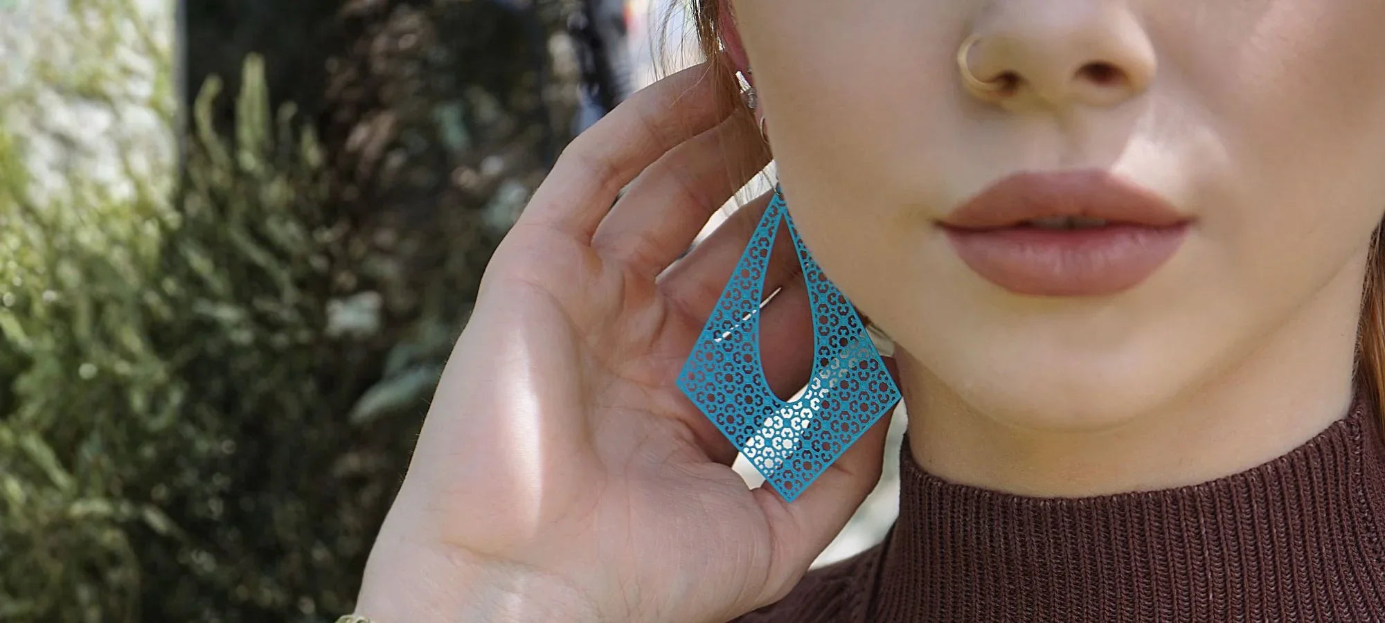 Model wearing blue geometric statement earrings from Sunbaked Lizard Jewellery & Gifts