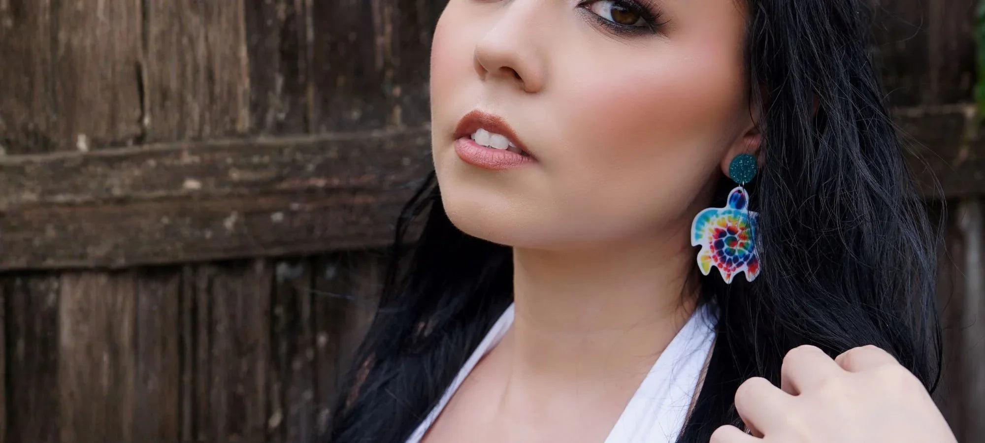 Model wearing tie dye turtle novelty earrings from Sunbaked Lizard Jewellery & Gifts