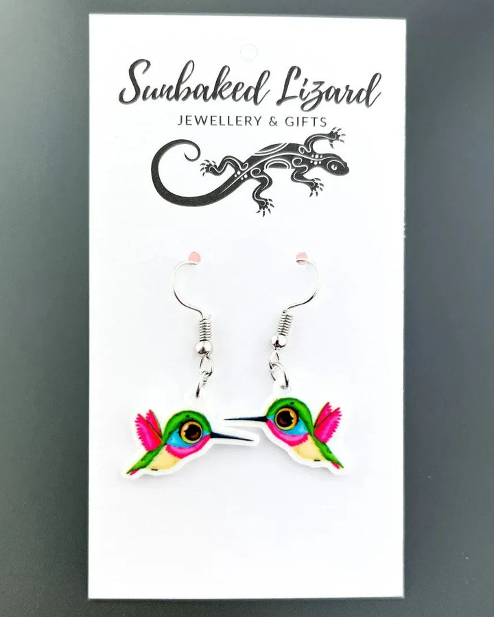 Honeyeater drop earrings, a colourful pink, green, and blue bird in flight on silver hooks on a Sunbaked Lizard backing card