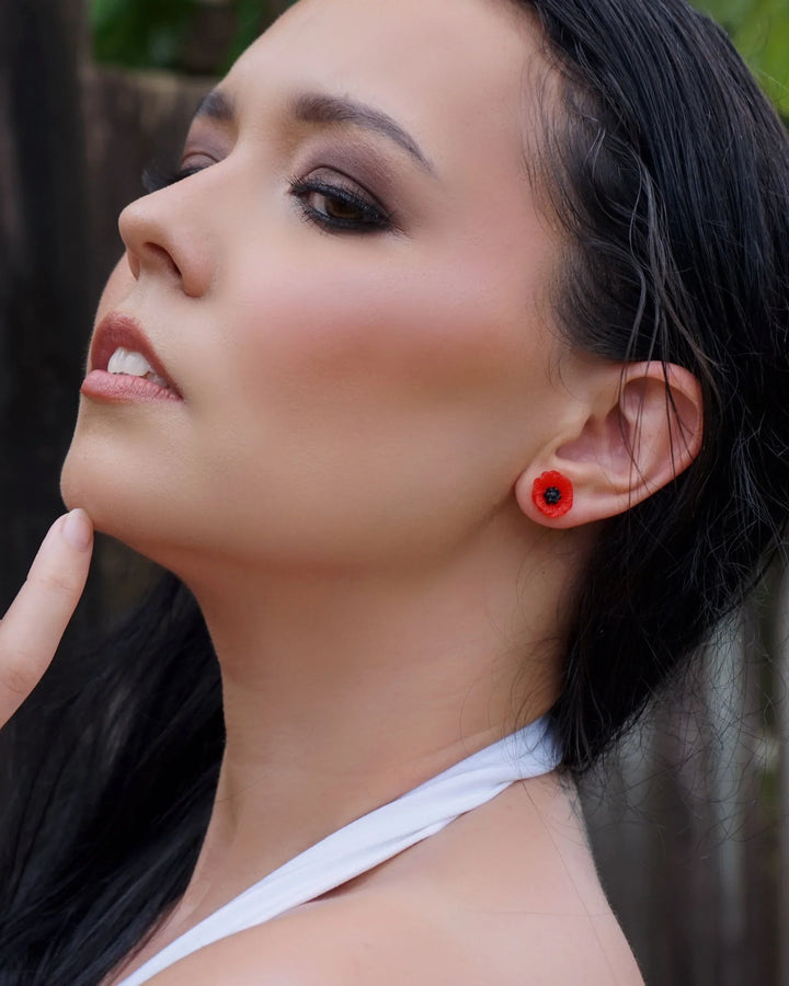 Side view of petite red poppy resin stud earrings on model