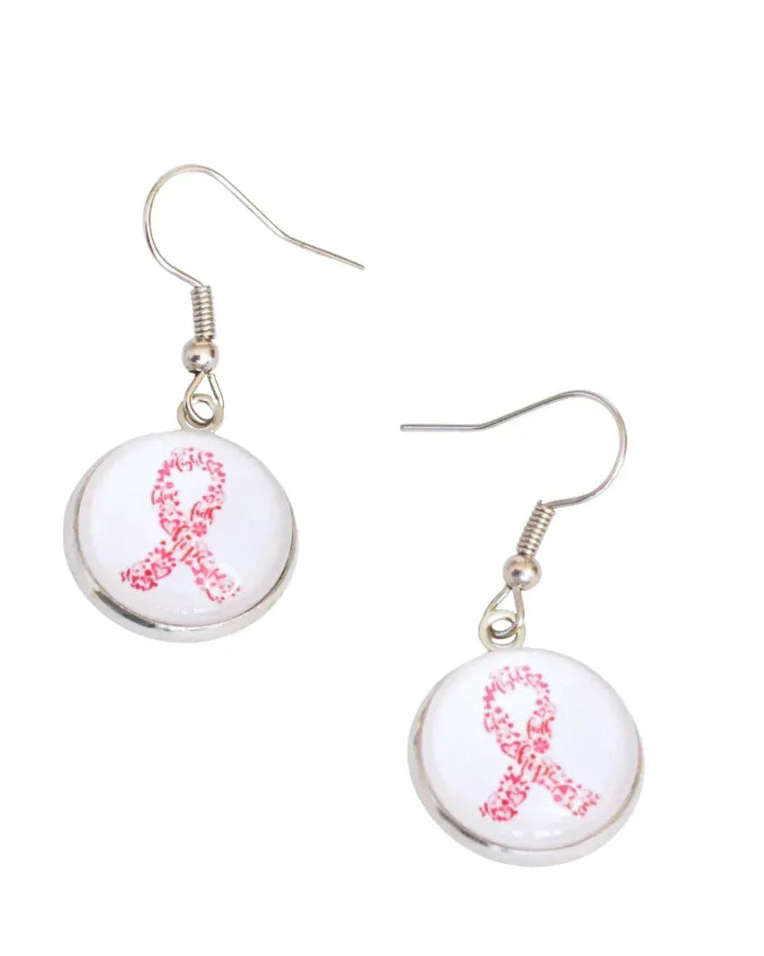 Close-up of pink ribbon drop earrings, a glass cabochon in a silver-tone setting on stainless steel hooks
