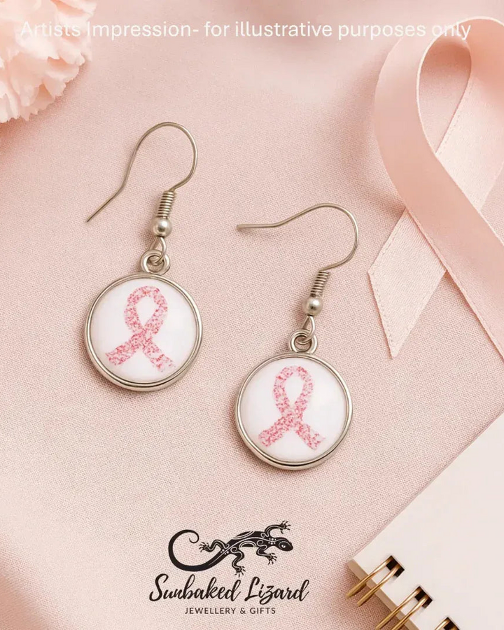 Flat lay of pink ribbon glass cabochon earrings for breast cancer awareness