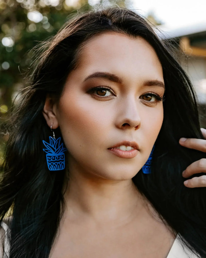 Model wearing blue potted plant statement earrings, showing the 60mm size against the jaw