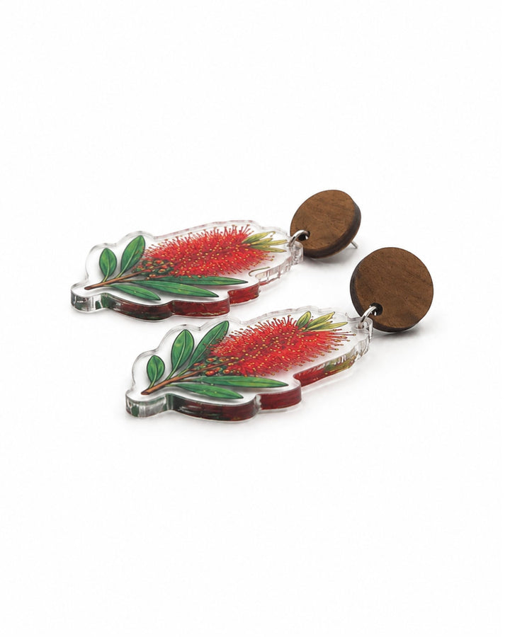 Side view of red bottlebrush earrings showing the flat clear acrylic charm and the wooden stud top