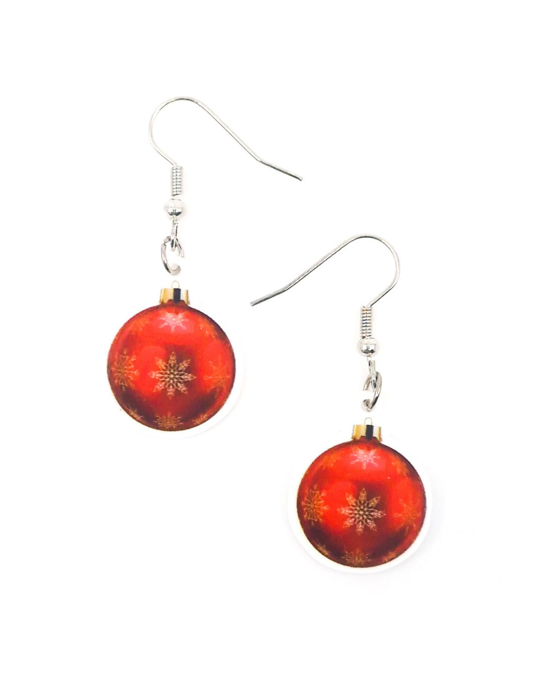 Red Christmas bauble earrings with gold snowflakes on a glossy acrylic charm, hanging from silver hooks