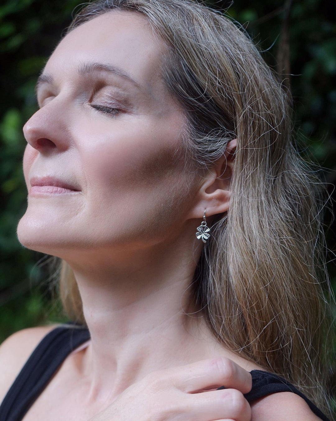Model wearing silver-tone Shamrock Four Leaf Clover Drop Earrings, lightweight lucky charm earrings for everyday wear and St Patrick&