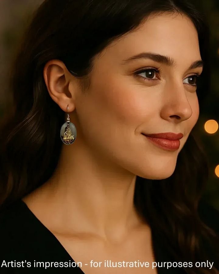 Model wearing a shimmering Christmas tree earring, showing the size against her ear