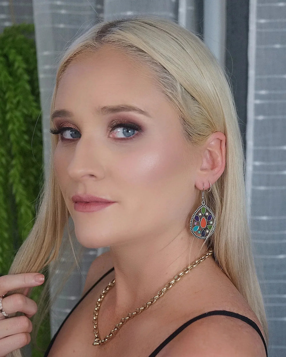 Model wearing silver mosaic teardrop statement earrings with multicolour stones