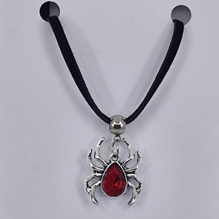 Silver spider pendant necklace with ruby-red gem-style body on black cord – creepy-cute Halloween jewellery