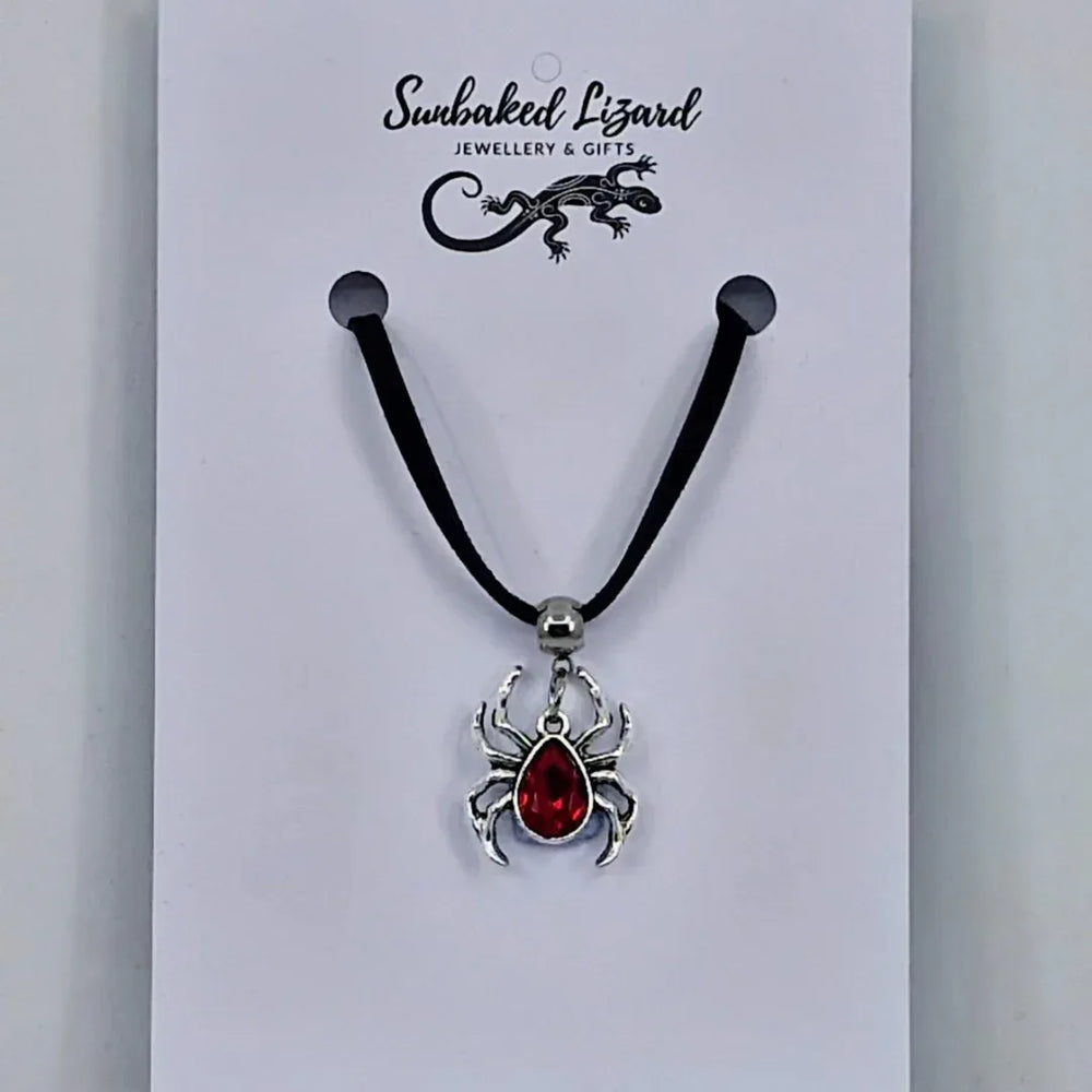 Silver spider pendant necklace with ruby-red gem-style body on black cord – creepy-cute Halloween jewellery
