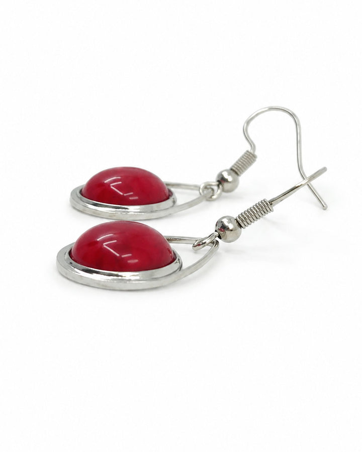 Side view of red stone teardrop earrings showing the domed stone and silver-coloured frame
