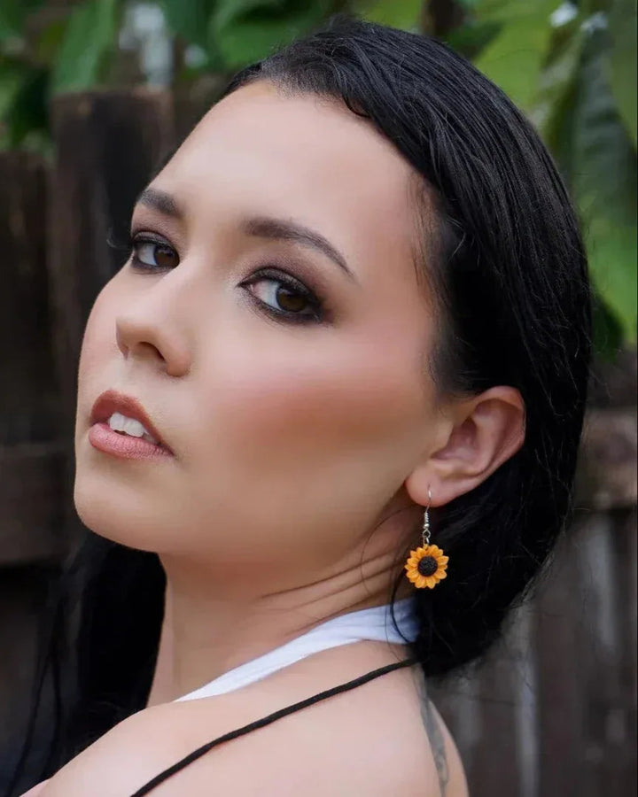 Model wearing 18mm sunflower drop earrings with golden petals and black centre