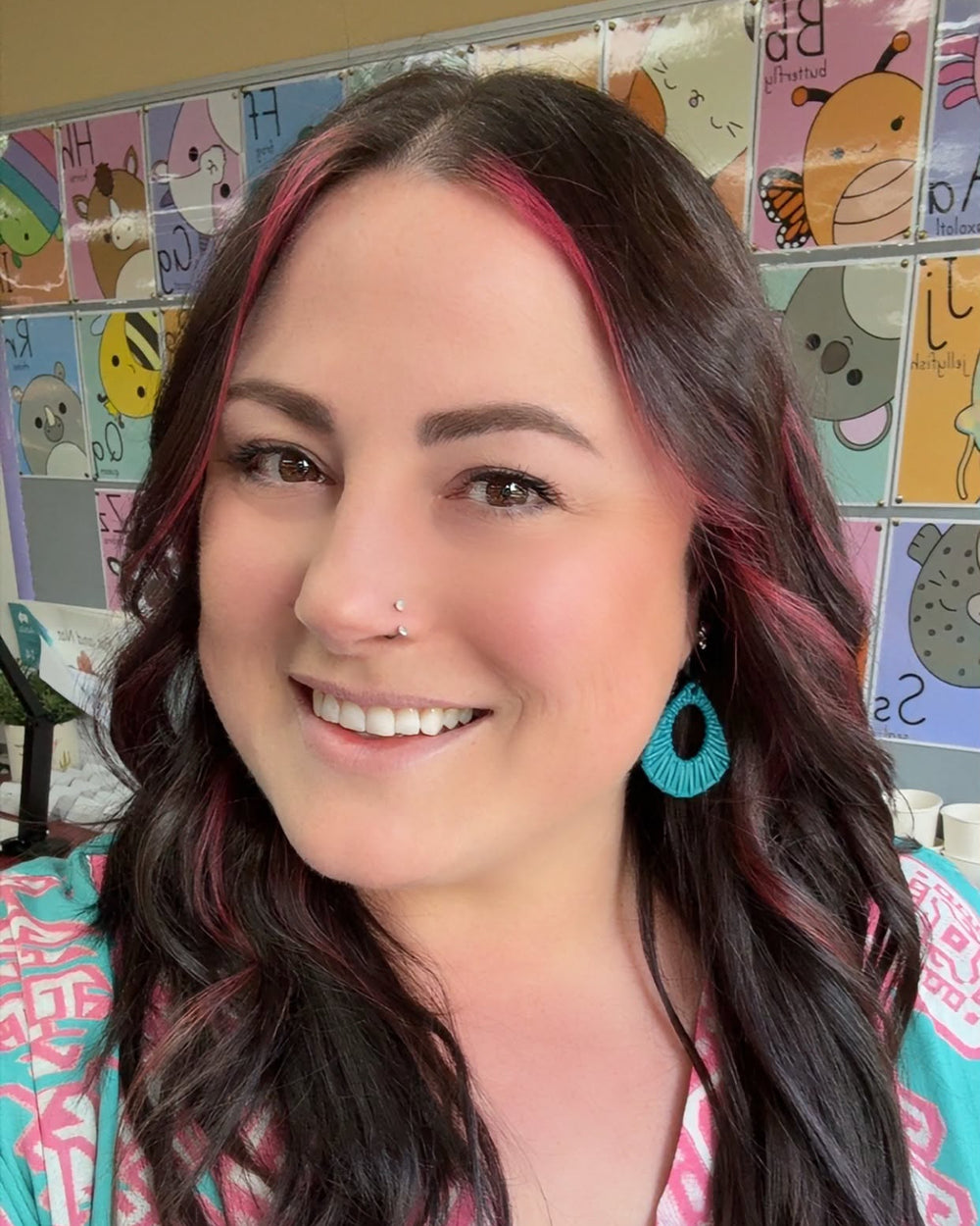 Teal Acrylic Woven Earrings worn with a colourful teal and pink outfit in a classroom.