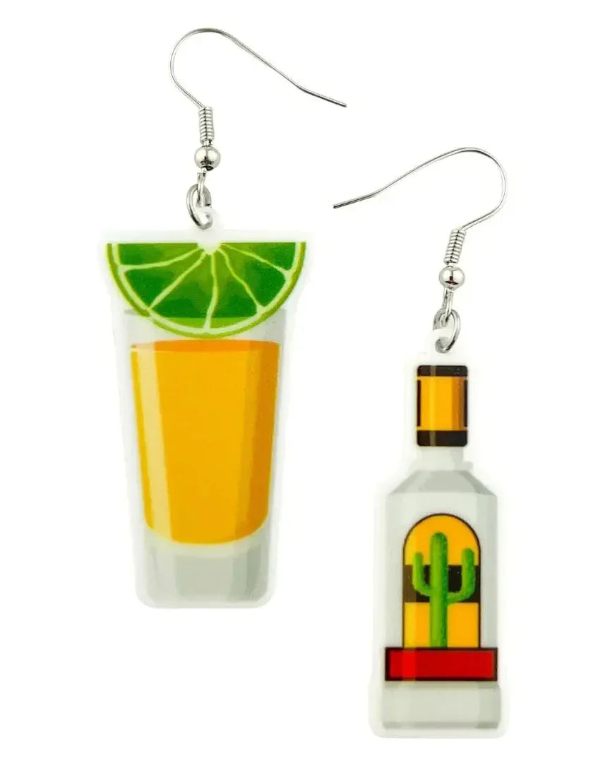 Mismatched tequila shot earrings featuring a bottle and a shot glass with lime on a white background