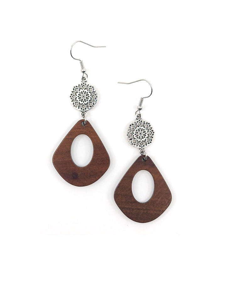 Close up of timber drop earrings with oval cut-out and silver mandala disc