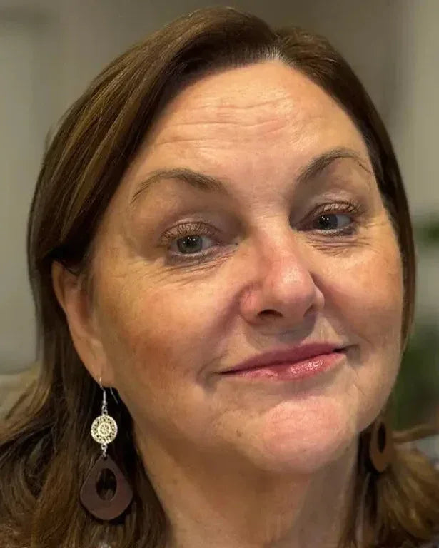 Woman wearing timber drop earrings with silver detail close up