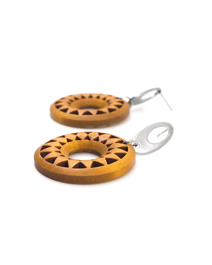 Detail photo of timber sun pendant drop earrings with circular cut-out sunburst design and silver stud top on a white background.