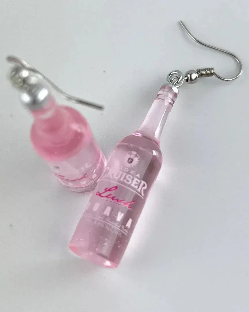 Close up of pink guava vodka earrings showing the bottle label and glossy finish.