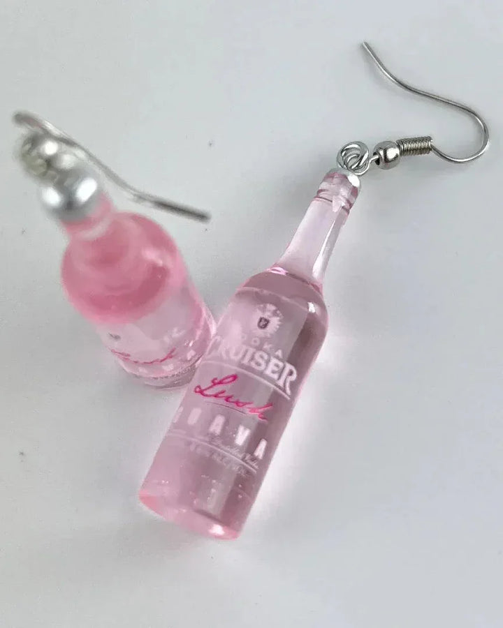 Close up of pink guava vodka earrings showing the bottle label and glossy finish.