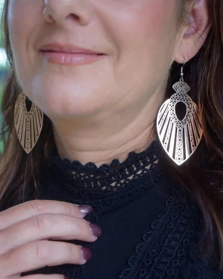 Model wearing filigree queen statement earrings showing oversized boho shape and intricate cut-out detail