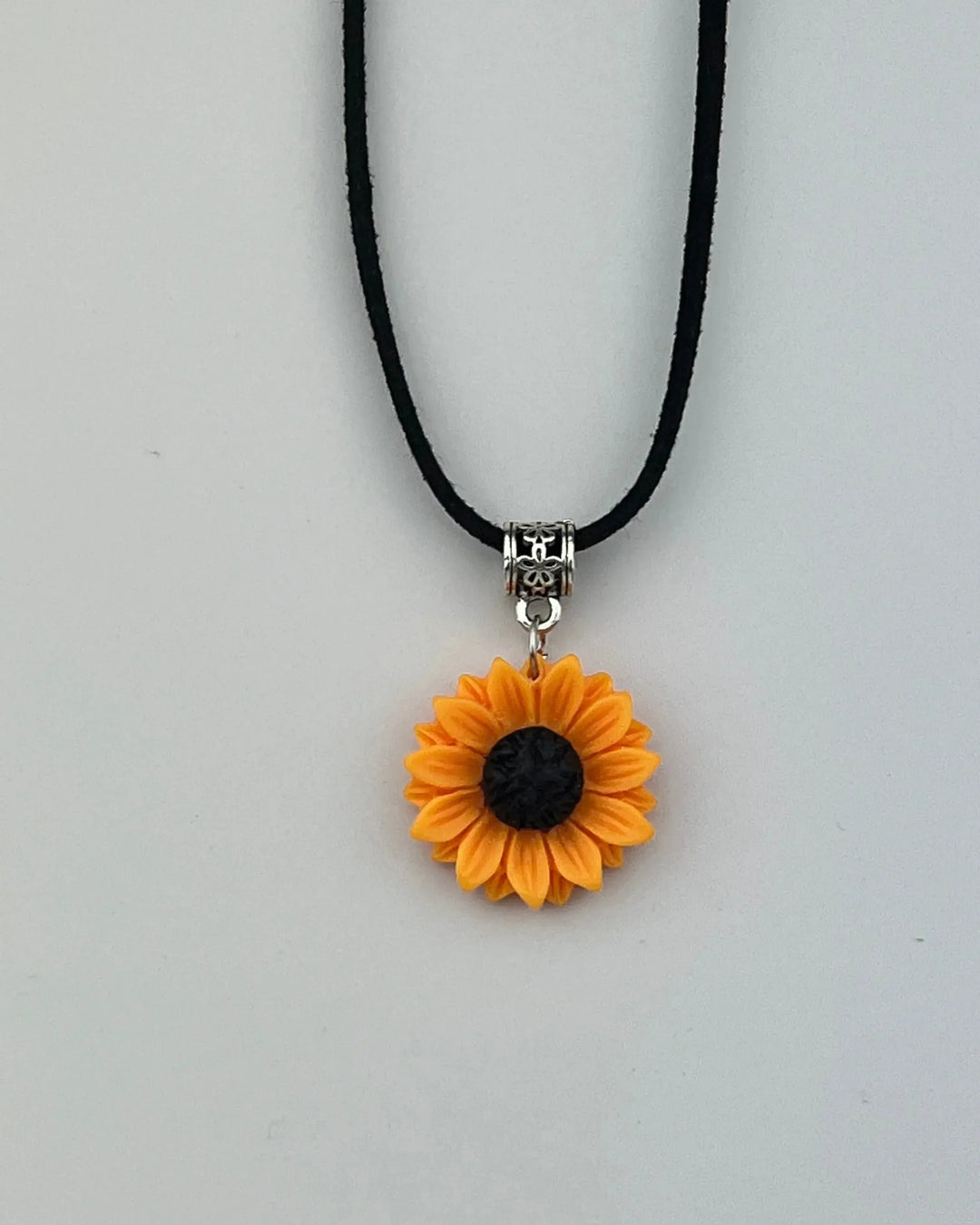 Yellow sunflower charm necklace with black centre on long black cord