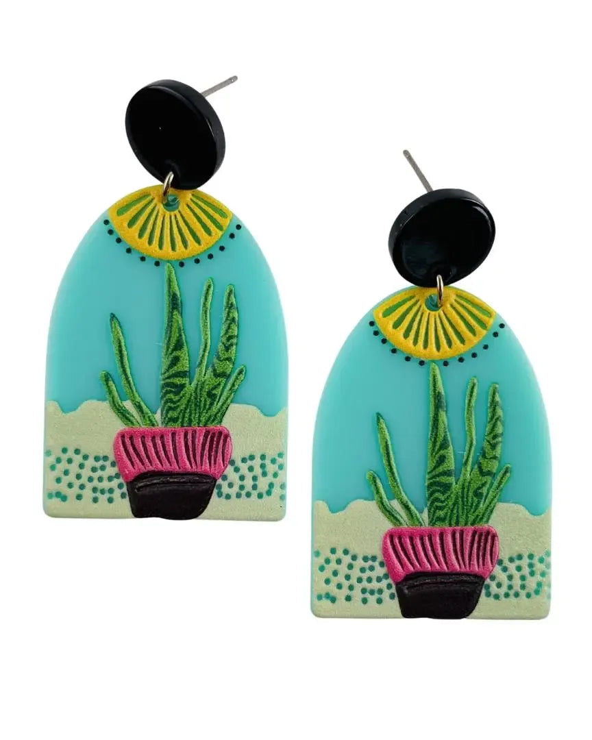 Statement arched earrings featuring a 2D cactus scene with a turquoise sky and pink pot.