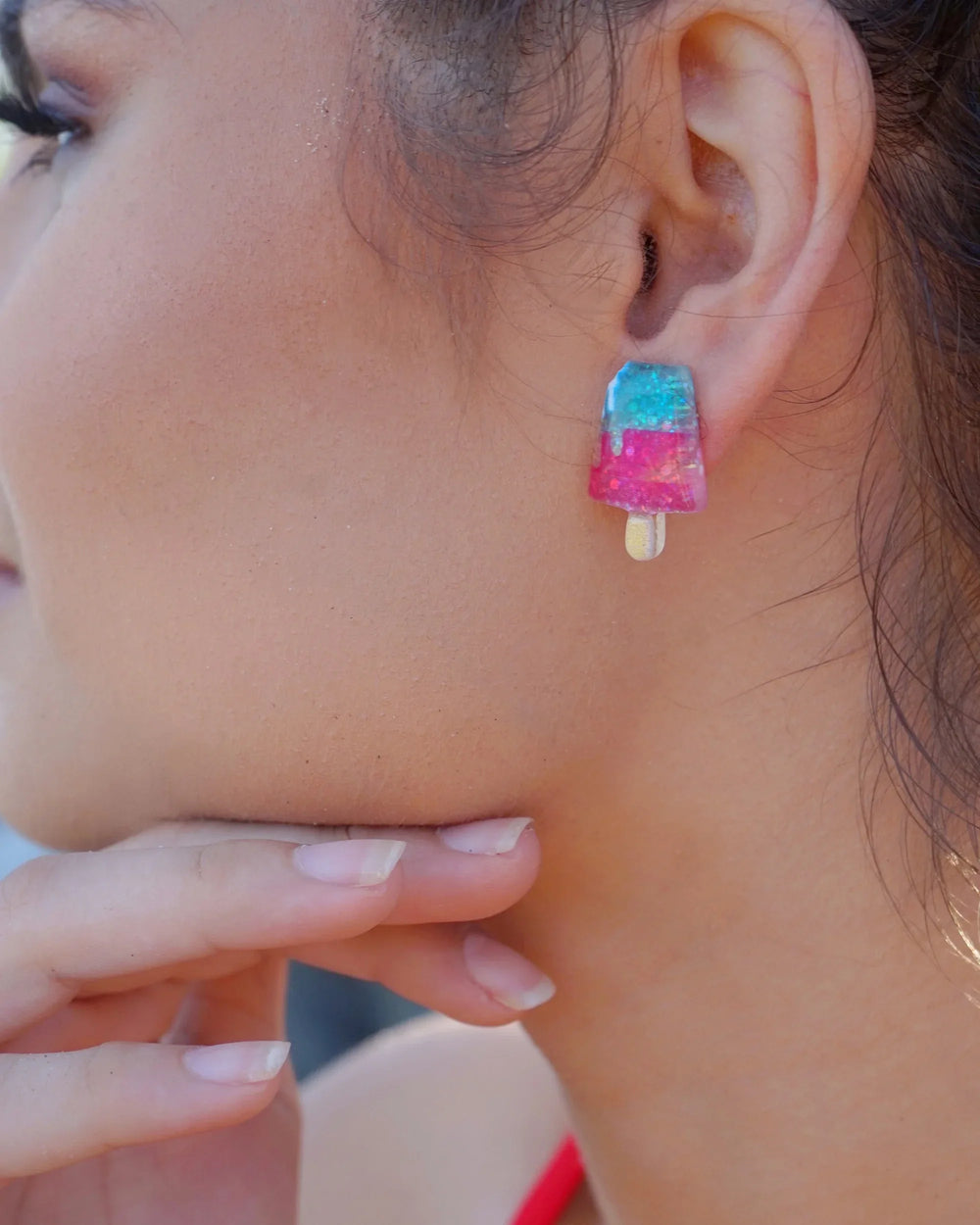 Glitter ice cream earrings worn on ear with pink, blue, and yellow resin charms