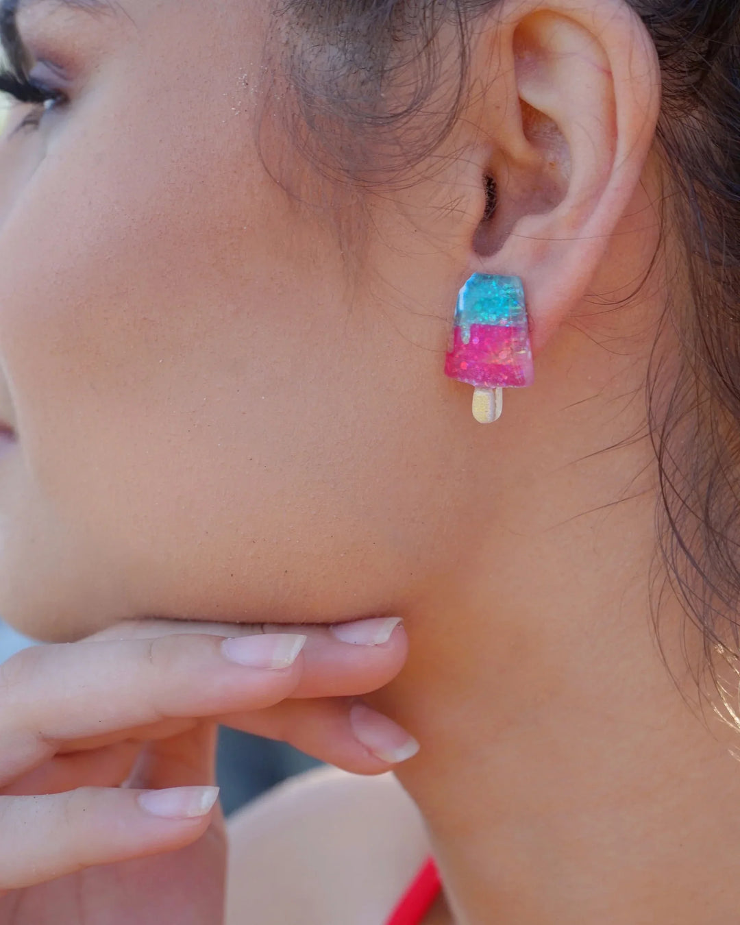 Glitter ice cream earrings worn on ear with pink, blue, and yellow resin charms