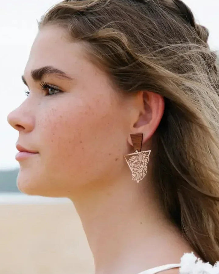 Timber and metal monstera leaf statement earrings on model