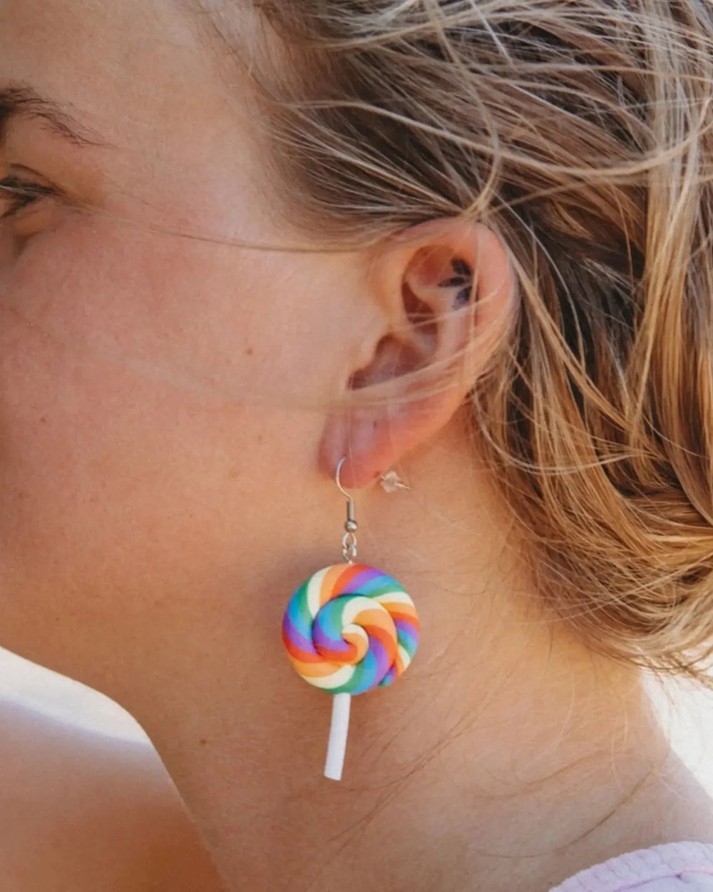 Model wearing rainbow lollipop earrings for Pride and Mardi Gras styling