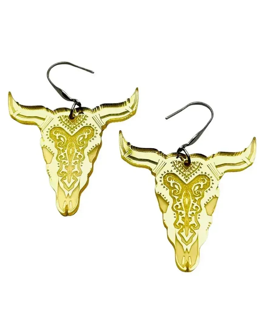 Shimmer gold bull head dangle earrings with engraved western pattern on white background.