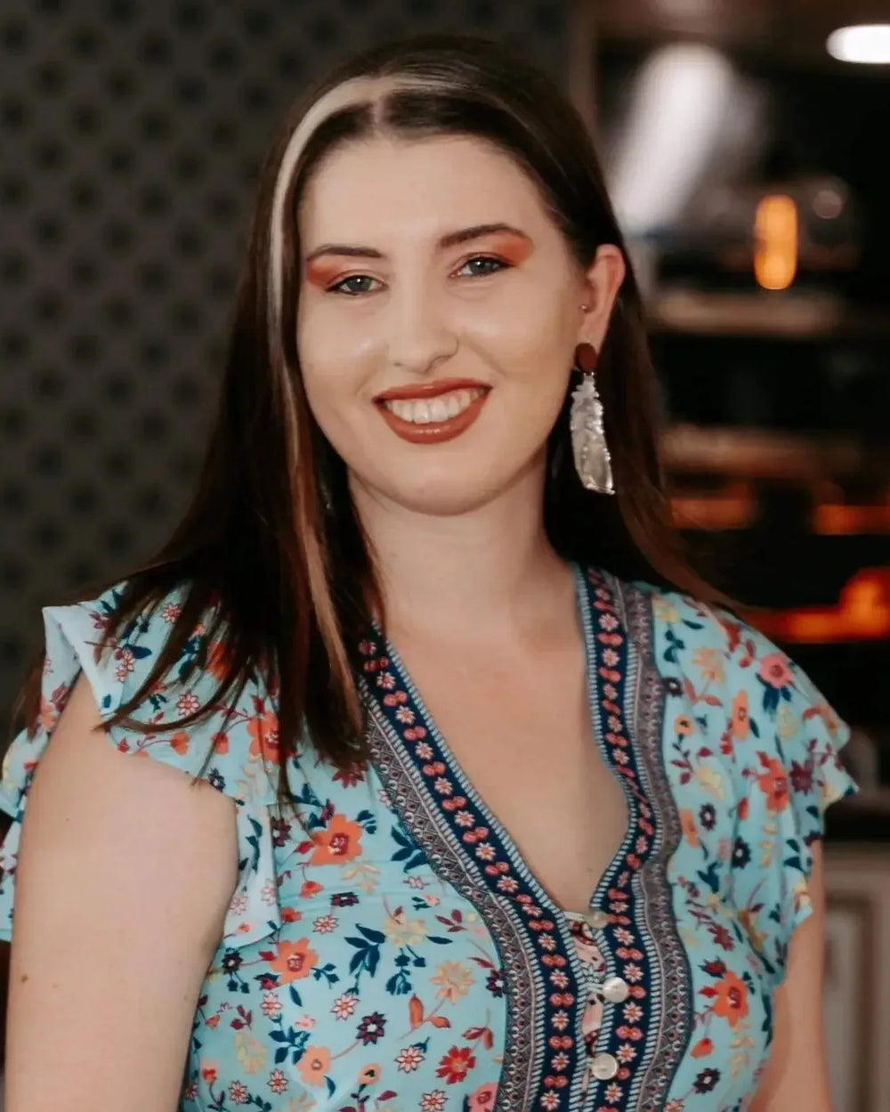 Model wearing silver shimmer feather dangle earrings with timber stud top