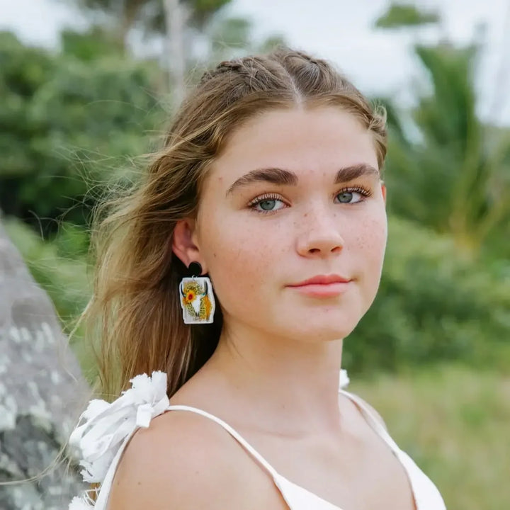 Model wearing western cow skull sunflower leopard print stud drop earrings with black round stud top